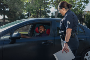 Officer questioning a man driving a car