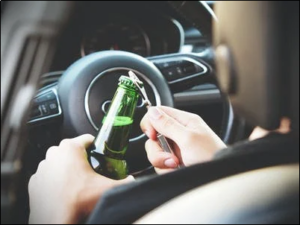 A driver trying to open a beer bottle