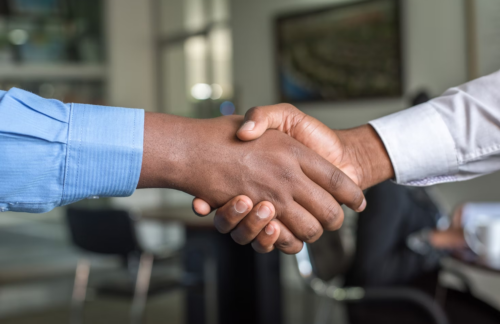 A high-risk auto insurance agent and his client shaking hands.