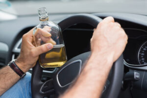 A person drinking alcohol while driving who will need FR44 DUI insurance.