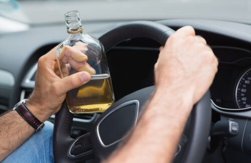 A person drinking alcohol while driving who will need FR44 DUI insurance.