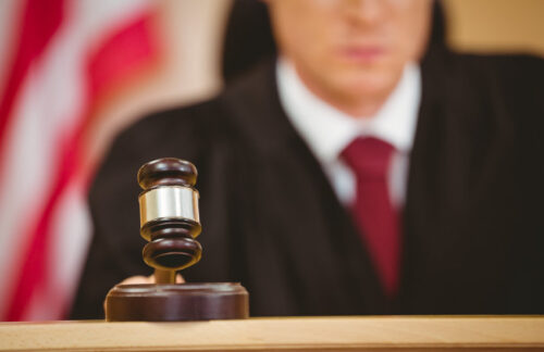 A Kansas judge banging a gavel in a courtroom to begin a Kansas DUI hearing.